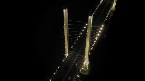 A cable-stayed highway bridge with tall concrete pylons illuminated by Stock Footage 257769954