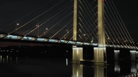 A cable-stayed highway bridge with tall concrete pylons illuminated by Stock Footage 257778451