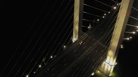 A cable-stayed highway bridge with tall concrete pylons illuminated by Stock Footage 257779613