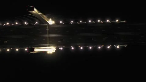 A cable-stayed highway bridge with tall concrete pylons illuminated by Stock Footage 257782253