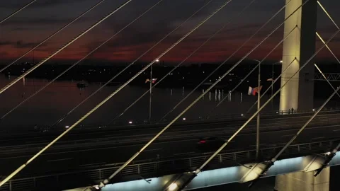 A cable-stayed highway bridge with tall concrete pylons illuminated by Stock Footage 257782363