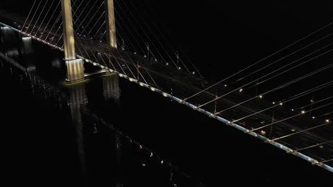 A cable-stayed highway bridge with tall concrete pylons illuminated by Stock Footage 257783724