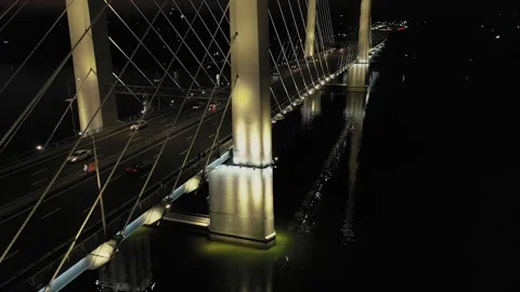 A cable-stayed highway bridge with tall concrete pylons illuminated by Stock Footage 257784589