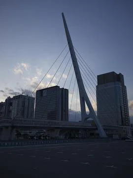 A cable-stayed pedestrian bridge with harbor towers at dusk, Japan Stock Photos