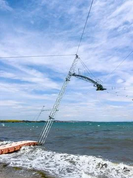 Cable system for wakeboarding in a lake with clear blue water and cloudy sky Stock Photos