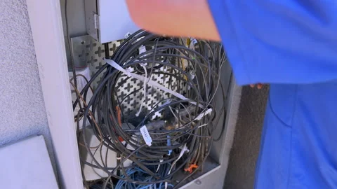 The Cable Technician secures the cables inside the Dmarc Stockbeeldmateriaal 312358845