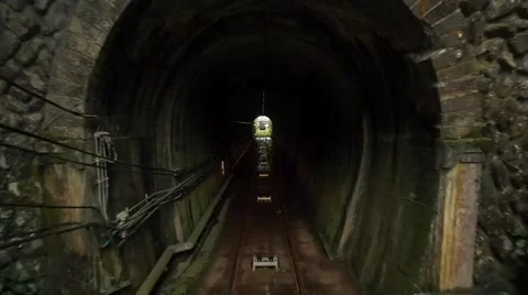 Cable tram train passing through dark mountainside tunnel. Stock Footage 40274187