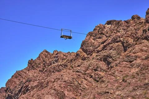 Cable Tramway Over Red Rock Cliffs Under Bright Blue Sky 스톡 사진