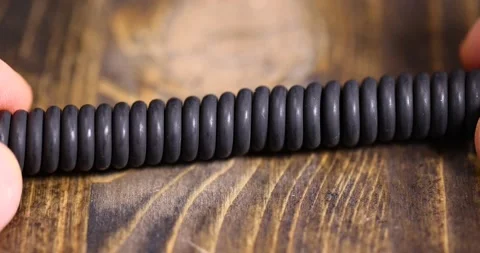 Cable twisted in the shape of a spring for equipment, an old black cable in a Stock Footage 313851079