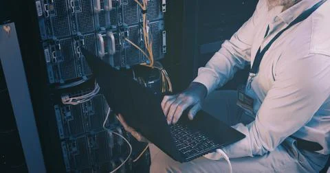 Cables, coding and hands with laptop, server room and network engineering with Stock-Fotos