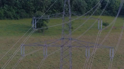 Cables connected to electric pylon over green pasture land Stock Footage 81532959