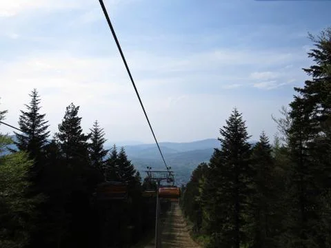 Cableway between Trees Surrounded by Forrest with View at Mountains Stock Photos