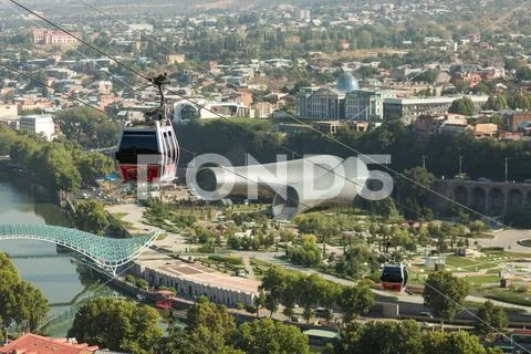Cableway with cable car over the most famous park and Peace bridge Stock Photos