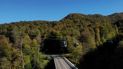 Cableway with moving funicular cabins over the mountain road with driving cars Stock Footage 204011272