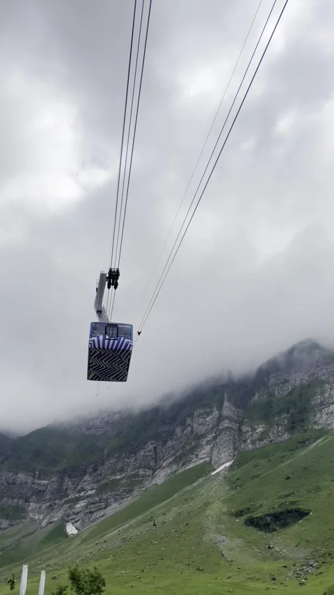 Cableway over green slopes and snowy peak Stock Footage 306067904