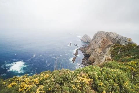 Cabo de Penas cliffs with ocean and coastal fog in Asturias 库存照片