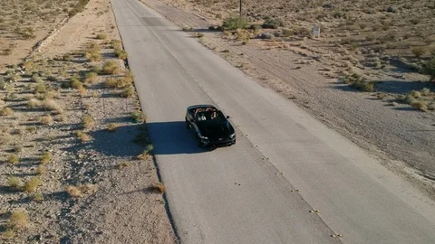Cabrio driving empty road - drone shot Stock Footage 107879288
