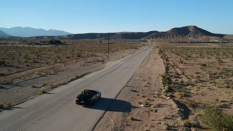 Cabrio driving empty road - drone tracking shot Video stock 107879292