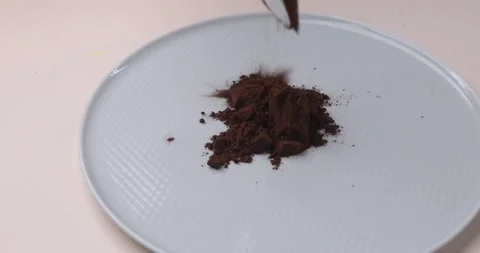Cacao powder falling down on a white plate. Isolated. Close-up. Stock Footage 165806071