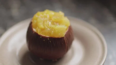 Cacos-shaped cake made of chocolate and passion fruit slices on a plate Stock Footage 300027198