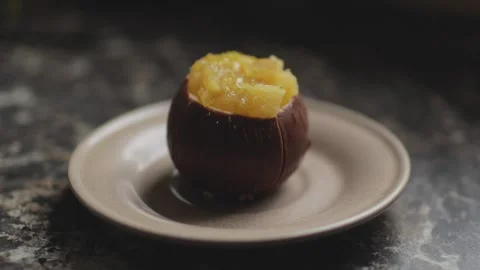 Cacos-shaped cake made of chocolate and passion fruit slices on a plate Stock Footage 300027200