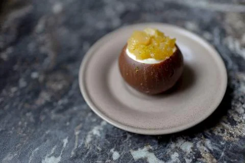 Cacos-shaped cake made of chocolate and passion fruit slices on a plate Stock Photos