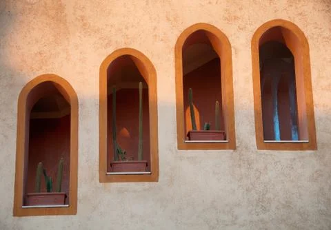 Cactus in window boxes of arched windows Stock Photos
