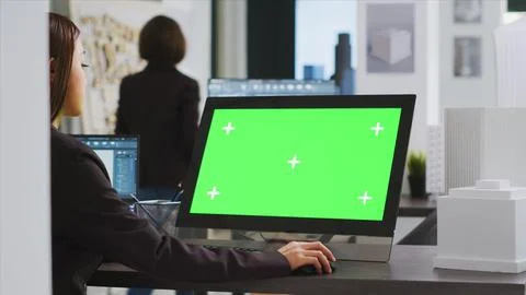 Cad specialist using computer with greenscreen at office desk Stock Photos