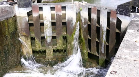 Caen Canal Locks. A view of a closed gate with water pouring through Stock Footage 40600469