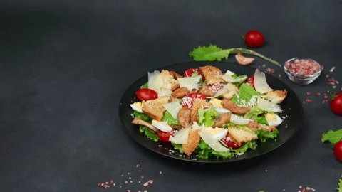 Caesar Salad in a black plate against a Black Background Video stock 237703449
