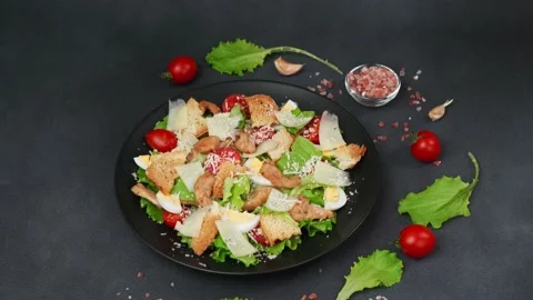 Caesar Salad in a black plate against a Black Background Stock Footage 237703473