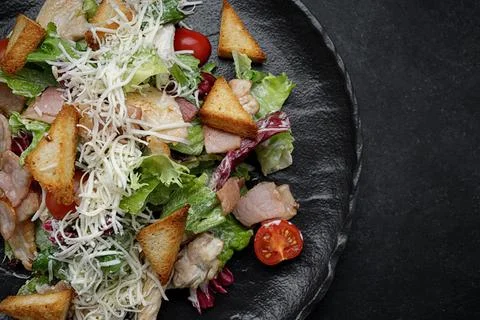 Caesar salad on a black plate. Horizontal Stock Photos