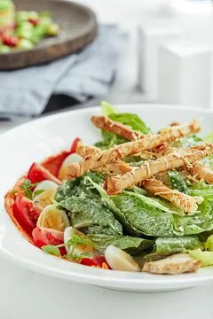 Caesar salad with bread sticks, quail eggs, cherry tomatoes and grilled chicken Foto stock