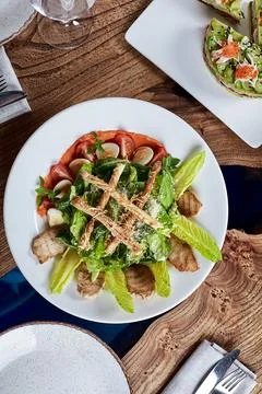 Caesar salad with bread sticks, quail eggs, cherry tomatoes and grilled chicken Foto stock