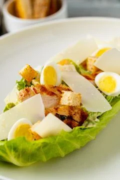 Caesar salad with chicken and eggs in modern plating Stock Photos