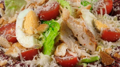 Caesar salad with chicken, boiled eggs, parmesan cheese, close-up view, loop Stock Footage 91032285