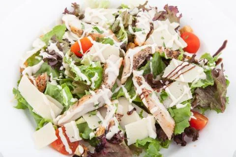 Caesar salad with chicken, cherry tomatoes, lettuce on white plate. Stock-Fotos