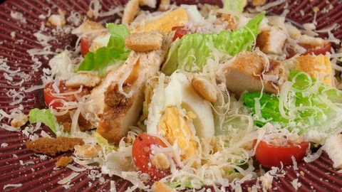 Caesar salad with chicken in red plate, served with boiled eggs, parmesan cheese Stock Footage 91031924