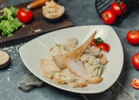 Caesar salad with chicken slice, crackers, tomato, cheese and parmesan Stock Photos