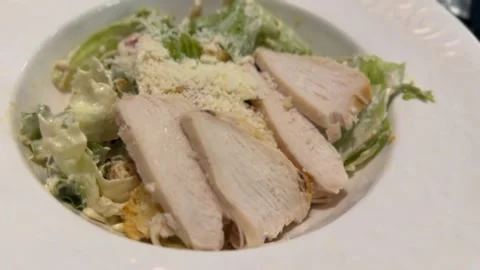 Caesar salad with chicken slices and parmesan cheese in white bowl, perfect.. Stock Footage 330397393