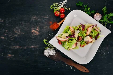 Caesar salad with chicken. Top view. On a wooden background. Copy space. Stock Photos