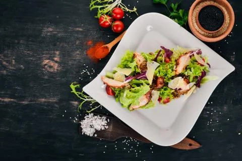 Caesar salad with chicken. Top view. On a wooden background. Copy space. Stock Photos