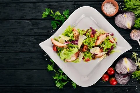 Caesar salad with chicken. Top view. On a wooden background. Copy space. Stock Photos