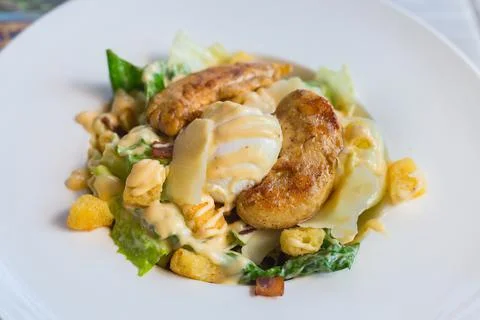 Caesar salad with fresh green vegetable is mixed with grilled chicken, boiled Stock Photos