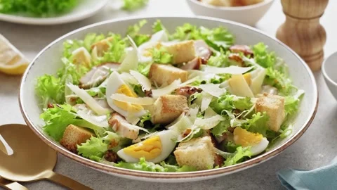 Caesar salad with lettuce, croutons, eggs, and grilled chicken breast Stock Footage 272254183