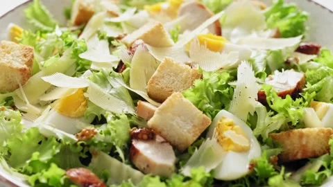 Caesar salad with lettuce, croutons, eggs, and grilled chicken breast Stock Footage 272254465
