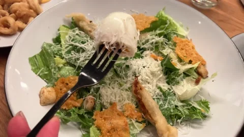 Caesar salad pick up salad with cheese pieces using a fork Stock Footage 292695905