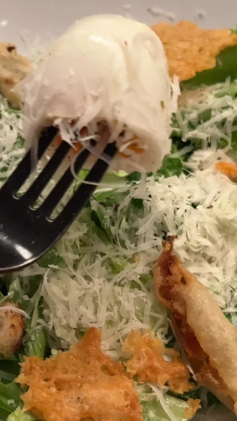 Caesar salad pick up salad with cheese pieces using a fork Stock Footage 293022469