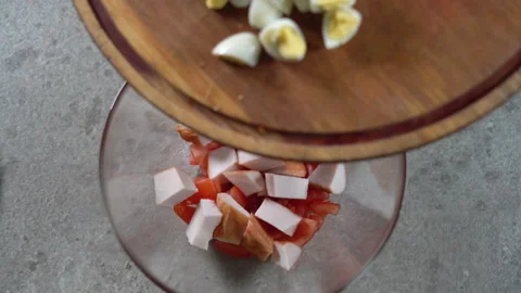 Caesar salad preparation process. The chef's hands toss sliced quail eggs into a Video stock 154575083