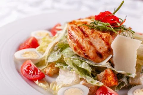 Caesar salad with quail eggs, cherry tomatoes, Parmesan cheese and grilled Stock Photos